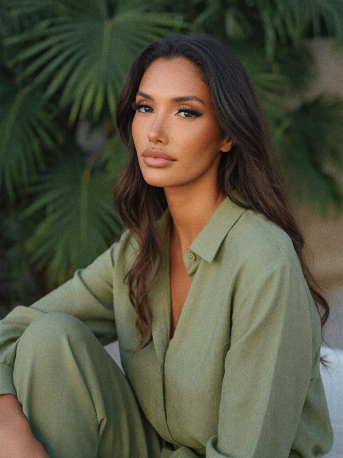 Linsi Silver in a sage linen shirt in front of palm fronds